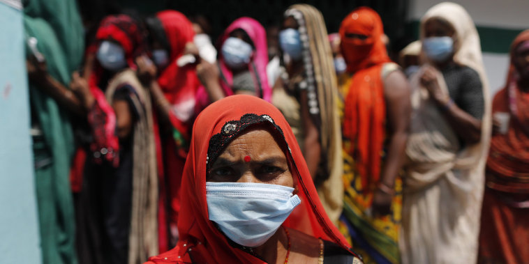Image: People wait to cast their votes during local panchayat elections on the outskirts of Prayagraj, in the northern Indian state of Uttar Pradesh