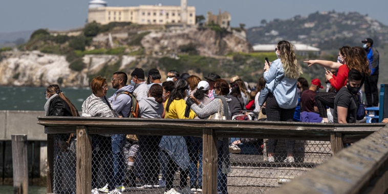Image: Visitors stand on Pier 39 in front of Alcatraz Island in San Francisc