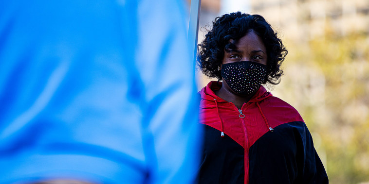 Image:; A woman listens as instructions are given to people waiting in line to check in at the Kentucky Career Center in downtown Louisville on April 15, 2021.