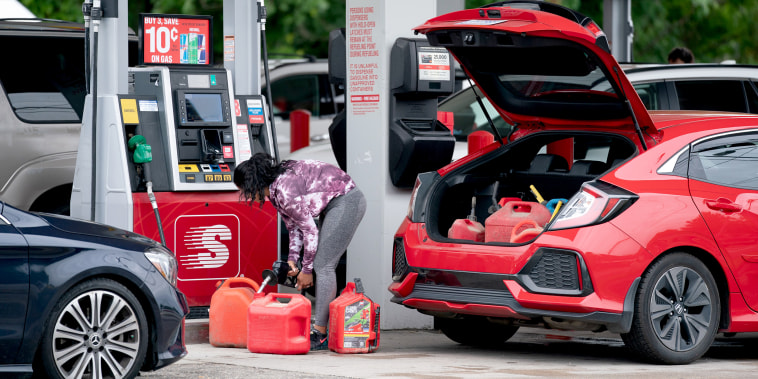 Image: A woman fills gas cans at a Speedway gas station on May 12, 2021 in Benson, N.C.