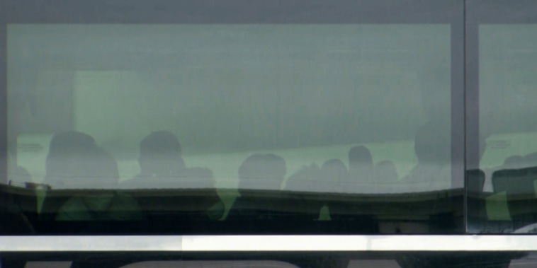 Image: Minors who migrated to the U.S. without their parents wait on buses in a parking lot outside the Kay Bailey Hutchison Convention Center in Dallas.