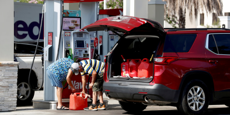 Image: A couple fills up multiple 5 gallon gas tanks at a Wawa gas station, run by Colonial Pipeline, in Tampa, Fla., on May 12, 2021.