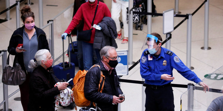 A TSA worker directs travelers to the next station at a security checkpoint at Seattle-Tacoma International Airport in SeaTac, Wash., on April 12, 2021.