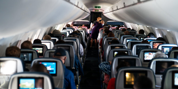 Flight attendants hand out refreshments to a packed Delta Airlines flight traveling from Arlington, Va., to Minneapolis on May 21, 2021.
