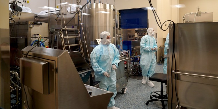 Employees work in a lab at Emergent Biosolutions, which is manufacturing vaccines for AstraZeneca and Johnson Johnson, on Feb, 8, 2021 in Baltimore, Md.