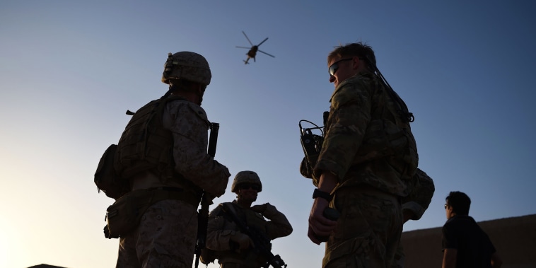 U.S. Marines and Afghan Commandos stand together as an Afghan Air Force helicopter flies past during a combat training exercise at Shorab Military Camp in Lashkar Gah in Helmand province, Afghanistan, on Aug. 27, 2017.
