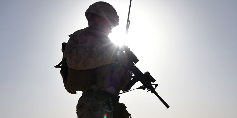 Image: A U.S. Marine watches Afghan Commandos take part in a combat training exercise at Shorab Military Camp in Lashkar Gah in Helmand province.