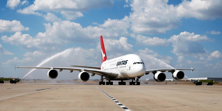 Dallas-Fort Worth Airport fire trucks provide a water cannon salute to a Qantas A380 during its inaugural landing on Monday, Sept. 29, 2014.