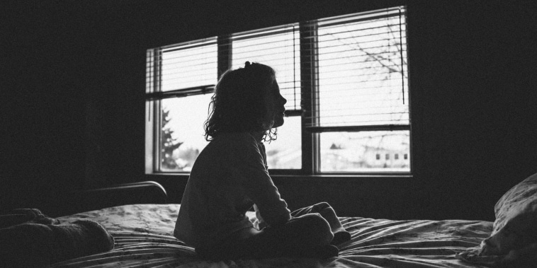 Silhouette of Little girl sitting on bed