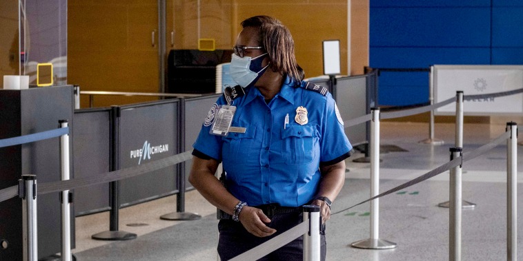 Image: A Transportation Safety Administration agent (TSA) stands near a security checkpoint in Detroit