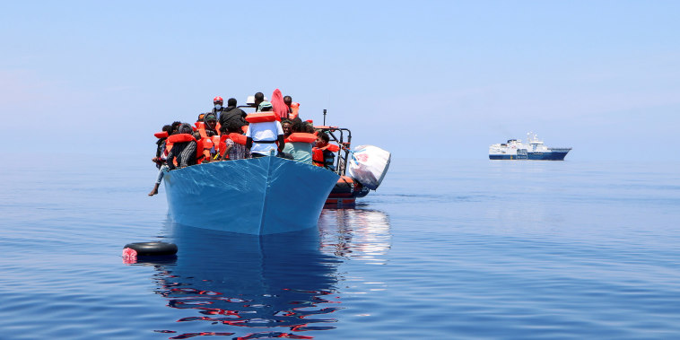 Image: Members of the Doctors Without Borders rescue migrants from a boat in the Mediterranean Sea