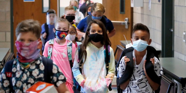 Wearing masks to prevent the spread of Covid, elementary school students walk to classes to begin their school day in Godley, Texas, on Aug. 5, 2020.