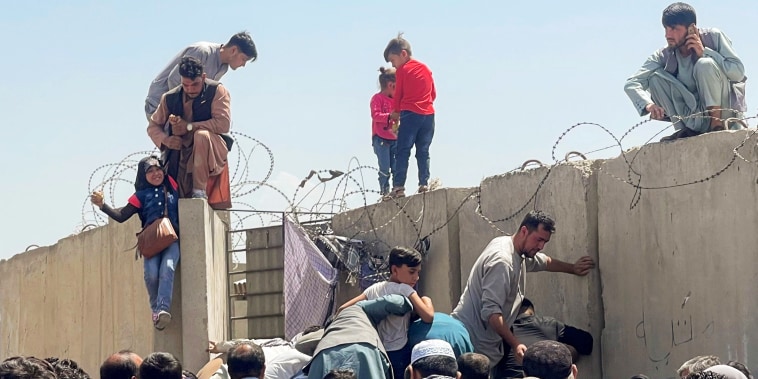 A man pulls a girl to get inside Hamid Karzai International Airport in Kabul, Afghanistan, on Aug. 16, 2021.