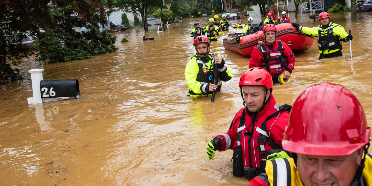 Image: Members of the New Market Volunteer Fire Company perform a secondary search during an evacuation effort following a flash flood, as Tropical Storm Henri makes landfall, in Helmetta, N.J.
