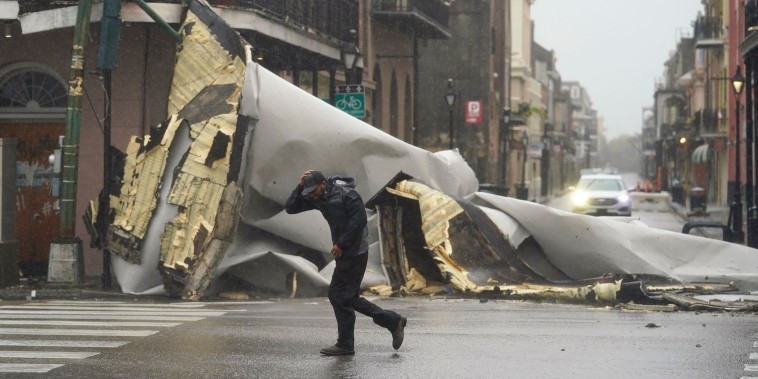 A man passes by a section of roof that was blown off of a building in the French Quarter by Hurricane Ida winds on Aug. 29, 2021, in New Orleans.