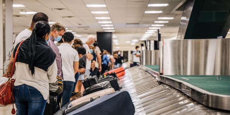 People wait for their luggage at an American Airlines baggage claim at the George Bush Intercontinental Airport on Aug. 5, 2021 in Houston, Texas.
