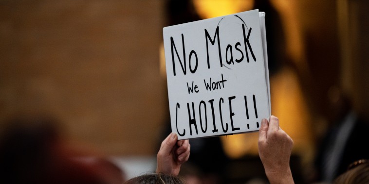 A demonstrator holds a sign protesting against mask mandates during a school board meeting for the Jefferson County Public Schools district in Louisville, Ky., on July 27, 2021.