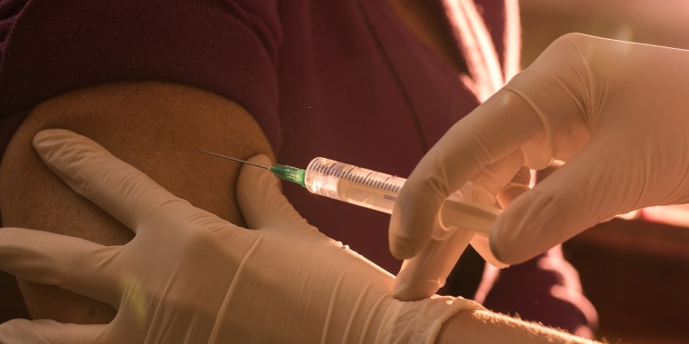 Close up unrecognizable nurse giving injection to senior women