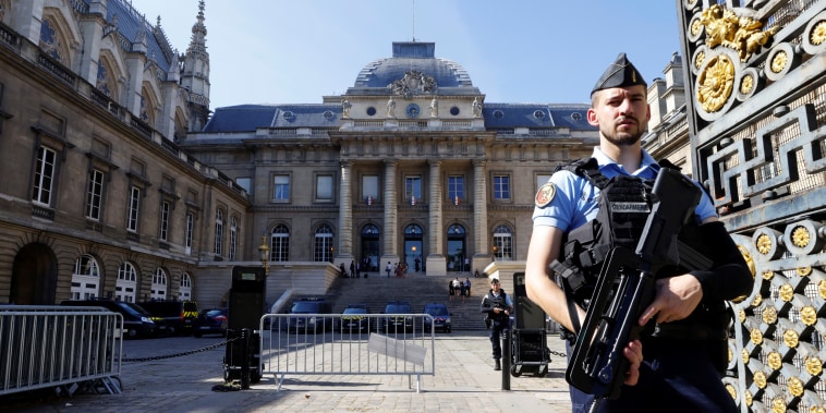 French police stand guard in front of the Paris courthouse on the Ile de la Cite in Paris