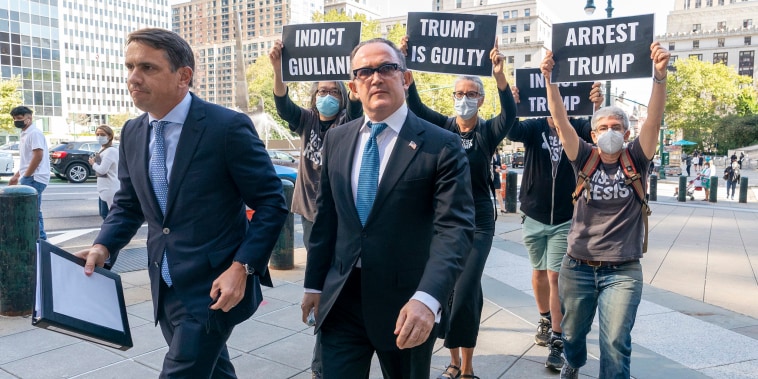 Image: Activist with Rise and Resist follow Igor Fruman, second from left, as he arrives in Federal court in Manhattan with his attorney Todd Blanche, on Sept. 10, 2021 in New York.