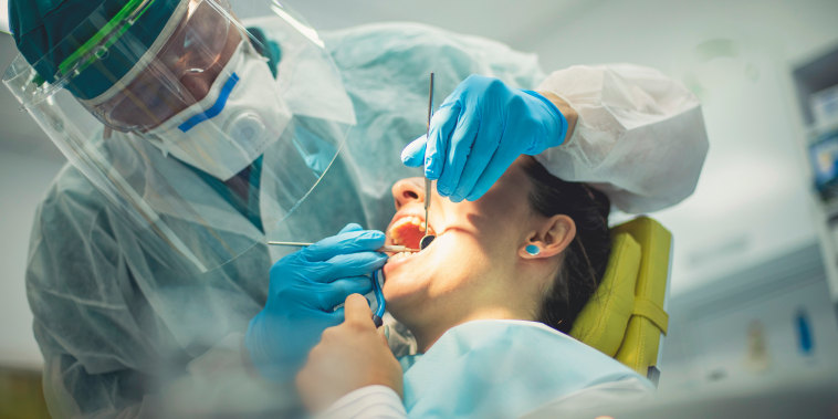 A dentist performs a procedure.
