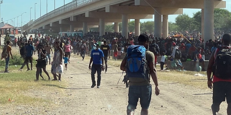 Image: Migrants are seen by the International Bridge between Mexico and the U.S., in Del Rio