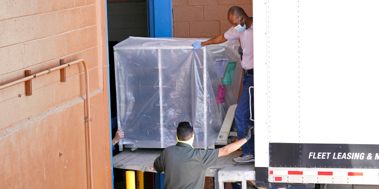 Image: Officials unload election equipment into the Veterans Memorial Coliseum at the state fairgrounds in Phoenix, on April 21, 2021