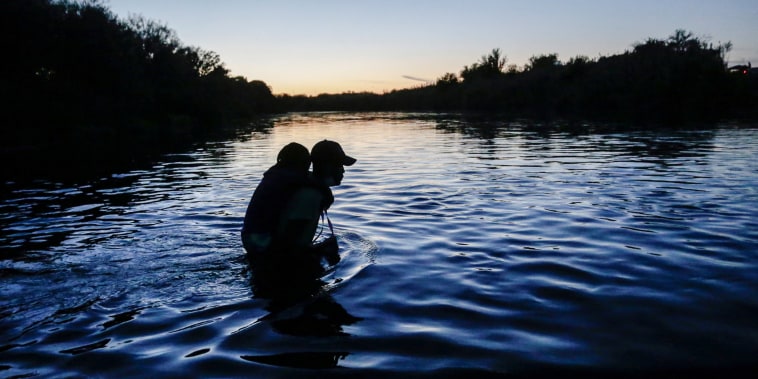 Image: A migrant seeking refuge in the U.S. crosses the Rio Grande river with his son on shoulders, at the border towards Del Rio, Texas, as seen from Ciudad Acuna, Mexico, on Sept. 23, 2021.