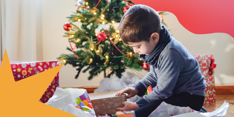 Little boy opening Christmas present under Christmas tree