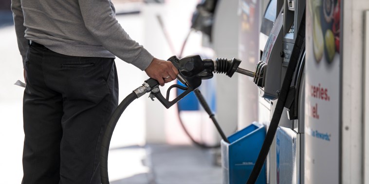 Image: A person holds a fuel pump nozzle at a Chevron Corp. gas station in Colma, Calif.