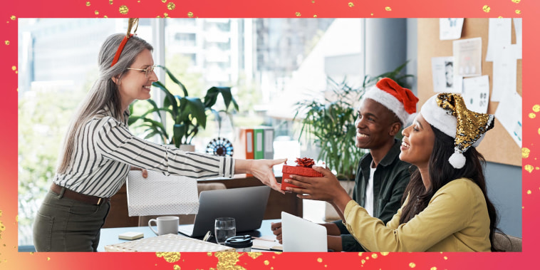 Group of businesspeople exchanging Christmas gifts in a modern office
