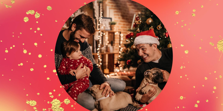 Two dads holding baby and puppies, celebrating Christmas