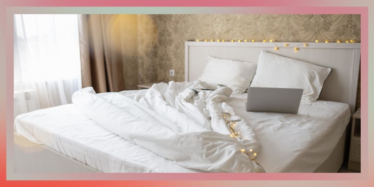 Image of a cozy empty bed spread out with a laptop