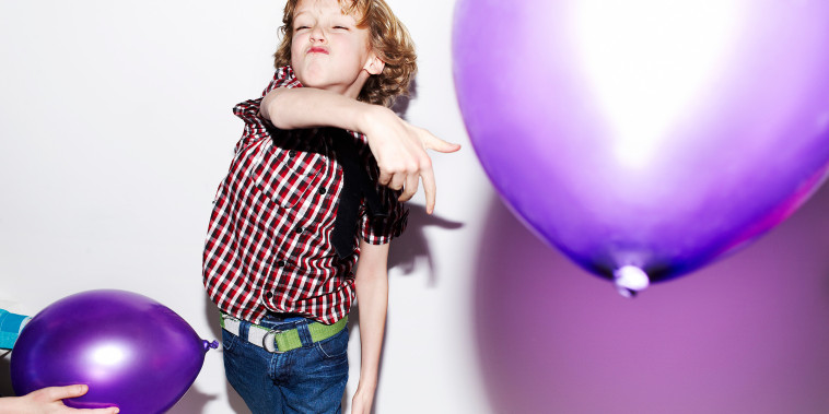 Boy playing with balloons at party