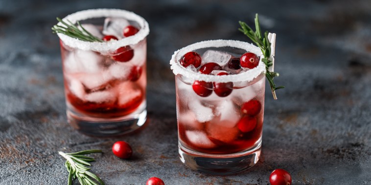 Cranberry cocktail with ice. Christmas cranberry beverage in glasses decorated with sugar and rosemary