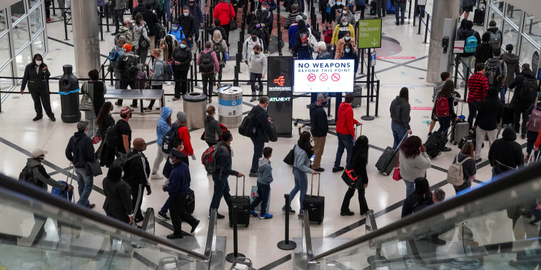 Image: Travelers form lines outside the TSA security checkpoint during the holiday season as the new Omicron Covid variant threatens to increase case numbers at Hartsfield-Jackson Atlanta International Airport on Dec. 22, 2021.