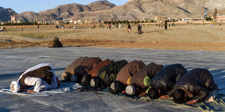 Image: Taliban fighters pray in a field in Herat on Feb. 4, 2022.