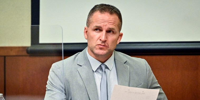 Former Louisville Police officer Brett Hankison examines a document as he answers questions from the prosecution March 2, 2022, in Louisville, Ky.