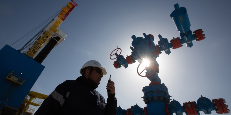 Image: A worker speaks on a handheld transceiver at a gas well near to the Gazprom PJSC gas drilling rig near Irkutsk, Russia, on April 7, 2021.