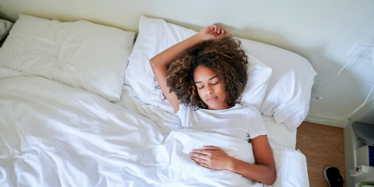 Young woman sleeping on bed in bedroom at home