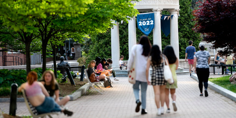 A Class of 2022 banner is displayed as students walk on campus at George Washington University in Washington, D.C., on May 2, 2022.