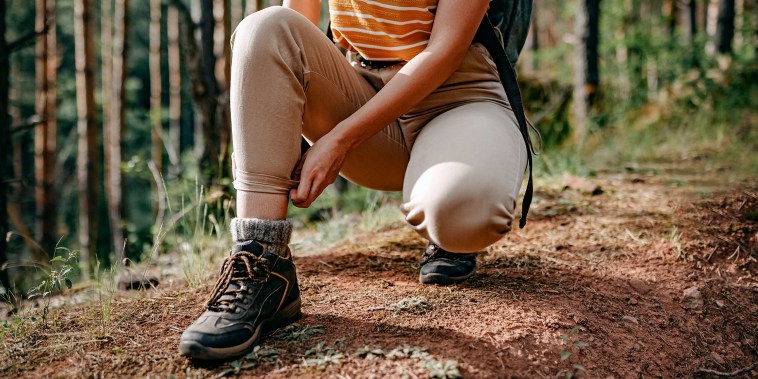 Female hiker tying the laces on her boots.