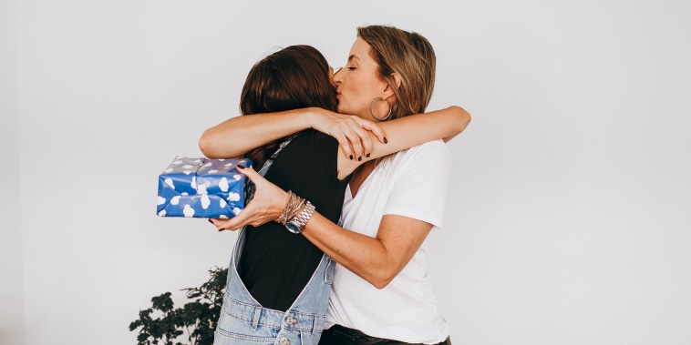 Mother and teenage daughter hugging during holiday gift exchange,Belo Horizonte,State of Minas Gerais,Brazil