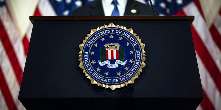 Image: The seal of the Federal Bureau of Investigation (FBI) hangs on a podium during a news conference.