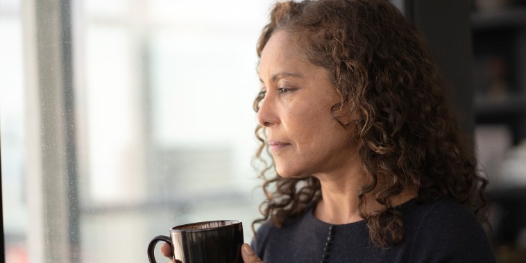 Portrait of a beautiful black woman drinking tea by window