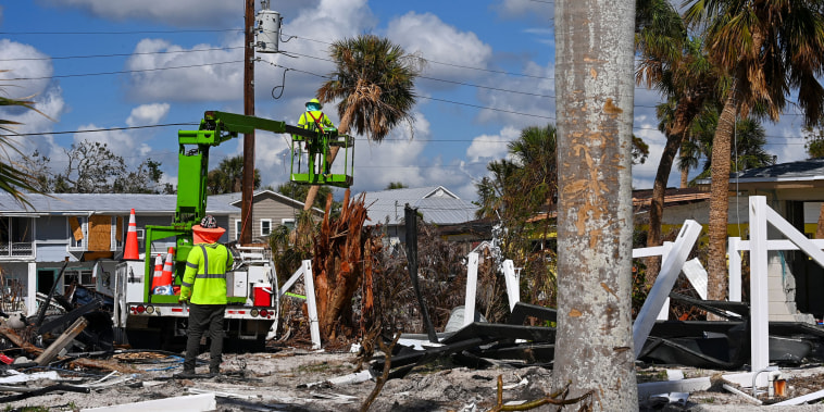 Utility workers repair lines in Fort Myers Beach, Fla.