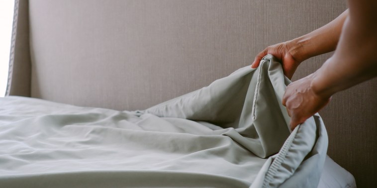Woman Puts Sheet on Bed