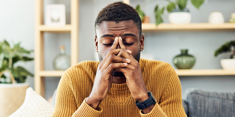 Shot of a young man looking stressed out at home