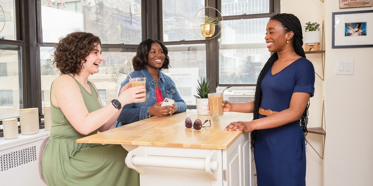 Three women around a kitchen island talking