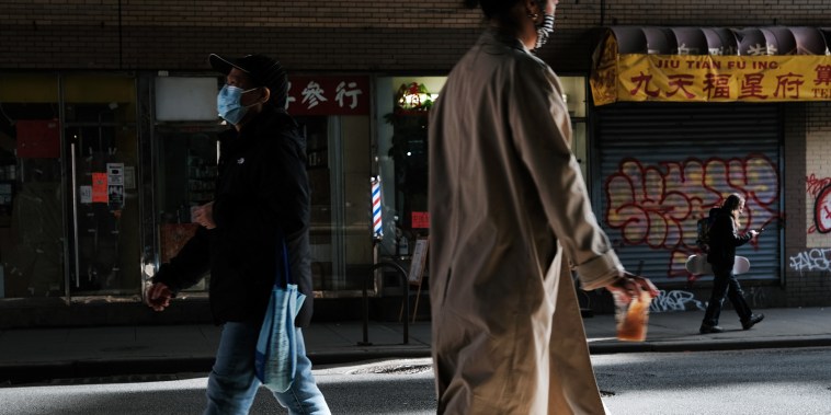Image: People walk through the streets of Chinatown on March 23, 2021 in New York City.